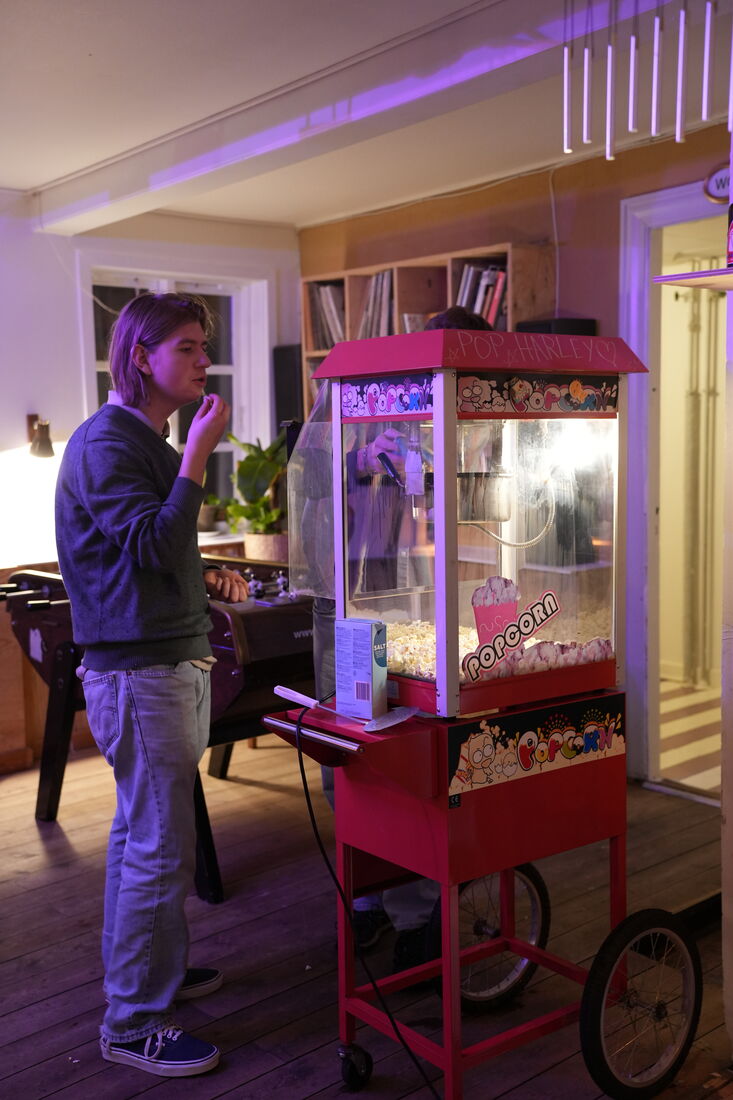 Person ved en popcornmaskine i neonlyst rum